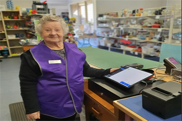 Older female volunteer in shop