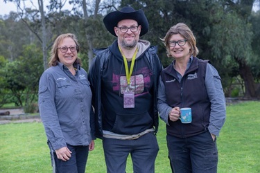 three volunteers smiling on lawn