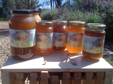 Six bottles of honey with the Heidi Honey logo on it, a cherub 