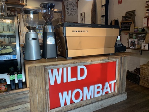 Wild Wombat Cafe signage in front of coffee machine 