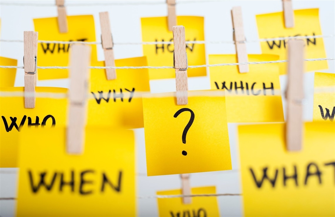 An image of post-it notes asking 'Why?' 'When?', 'Who?', 'What?', and 'Which?'