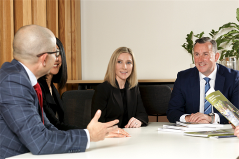 A group of professionals are sitting around a table in discussion