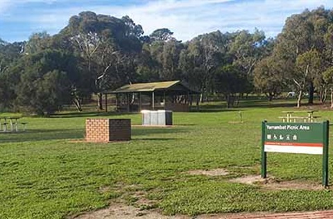 Photo of Yarrambat Park showing a grassed area with BBQ shelter and picnic tables