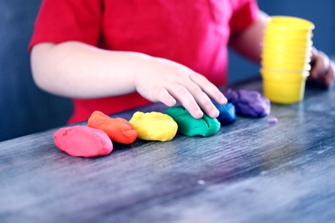 This is a stock image of a child playing with play dough.