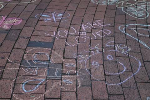 This is a photograph of a chalk drawing of a butterfly and the words you are loved.