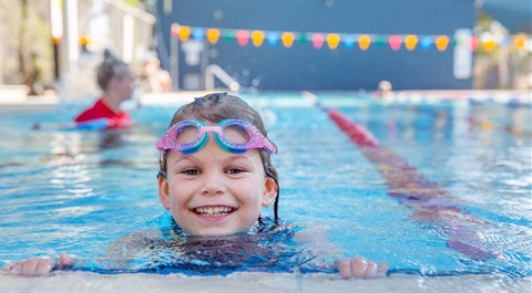 Photo of a child swimming in an outoor pool